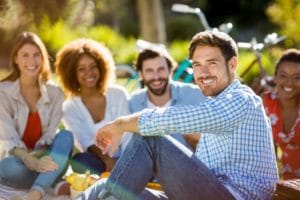 man smiling with friends after completing Oceanfront Recovery's residential treatment program