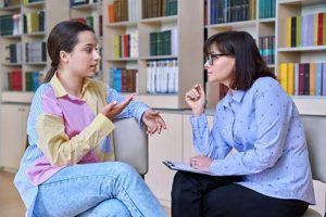 a young woman discusses her mental health with a licensed counselor in a depression treatment program