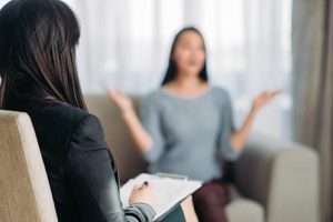Client on couch talking to doctor in Adderall addiction treatment