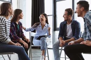 Woman talks to peers in alumni meeting