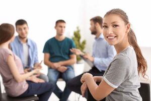 Woman smiles as she connects with others in group therapy